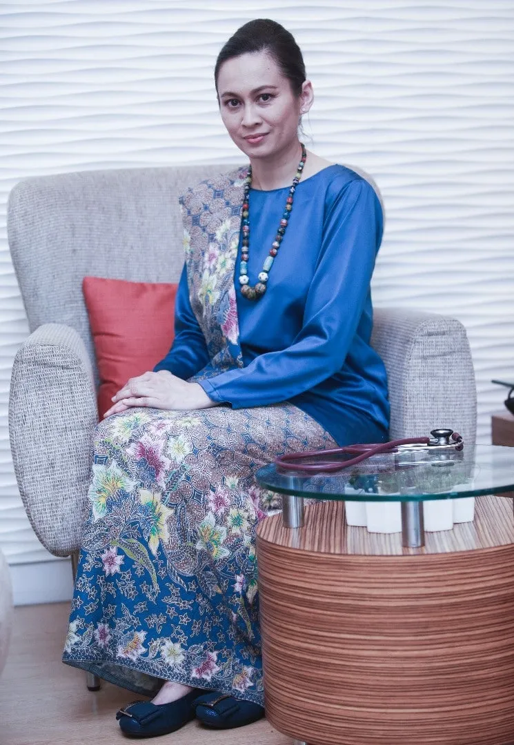 Dr Kartini Farah Rahim seated in a blue baju kurung