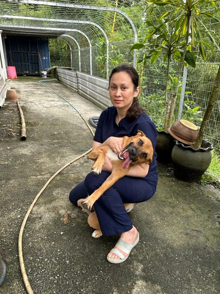Dr Kartini crouching with a rescued dog