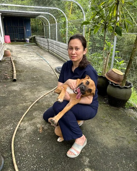 Dr Kartini crouching beside a rescued dog