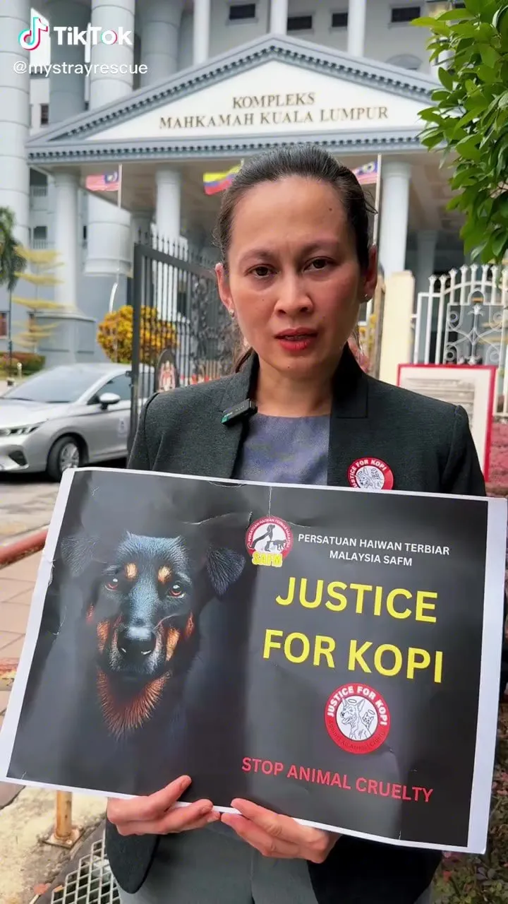 Dr Kartini holding a Justice for Kopi placard outside the Kuala Lumpur court complex